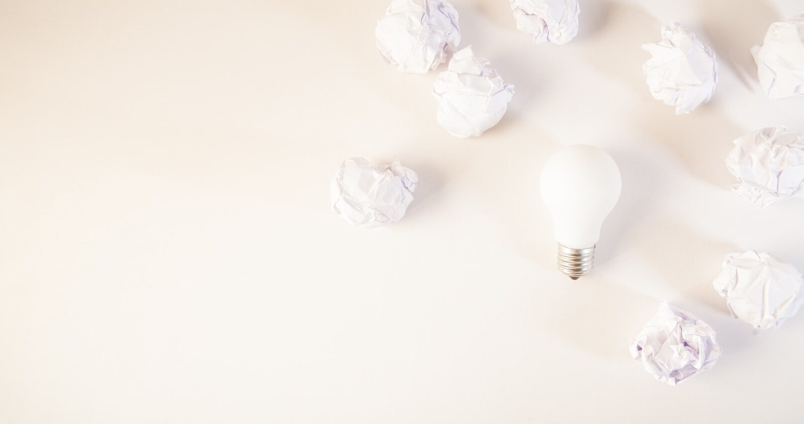 Light bulb surrounded by crumpled paper balls.
